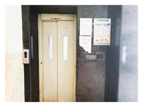 a wooden door in a wall with signs on it at Pride Pitu পিটু Near The Amrabati Park AC OR NON AC Both Facility in Digha