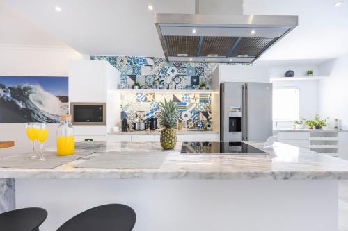 a kitchen with a counter with two glasses of orange juice at Casa da Praça - Vila do Bispo, Algarve in Vila do Bispo