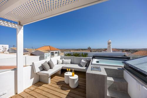 a patio with a couch and a table on a roof at Casa da Praça - Vila do Bispo, Algarve in Vila do Bispo