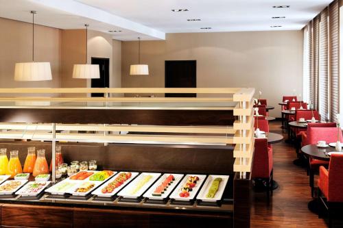 a restaurant with a bunch of food on display at NH Düsseldorf Königsallee in Düsseldorf