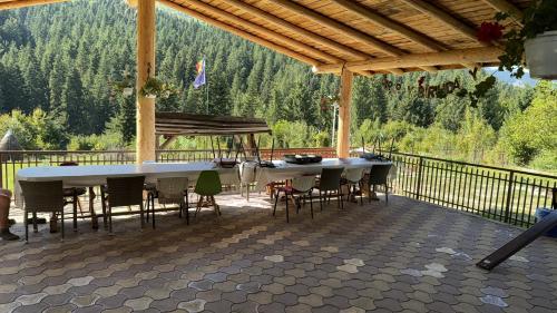 a patio with a table and chairs on a deck at La Butuci in Taşca
