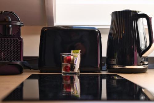 a toaster sitting on a kitchen counter with a glass at MátraForRest in Mátraszentistván