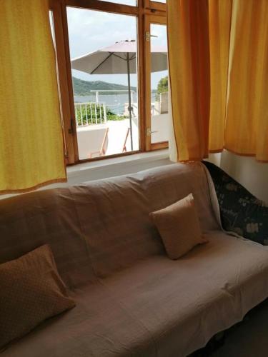 a couch sitting in a room with a window at Apartment in Primosten with sea view, balcony, air conditioning, WiFi 5155-1 in Primošten