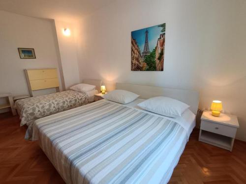 a bedroom with two beds and a picture on the wall at Apartment in Primosten with sea view, balcony, air conditioning, WiFi 5155-1 in Primošten