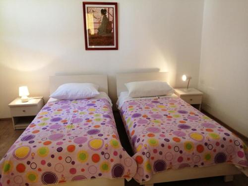 a bedroom with two beds and two lamps and a picture on the wall at Apartment in Primosten with sea view, balcony, air conditioning, WiFi 5155-1 in Primošten