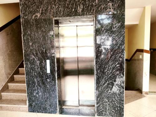 a glass door in a room with a staircase at Hotel RN Residency - Near Prem Mandir Vrindavan in Vrindāvan