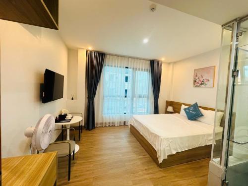 ニンビンにあるSky Hotelのベッドと机と窓のある寝室