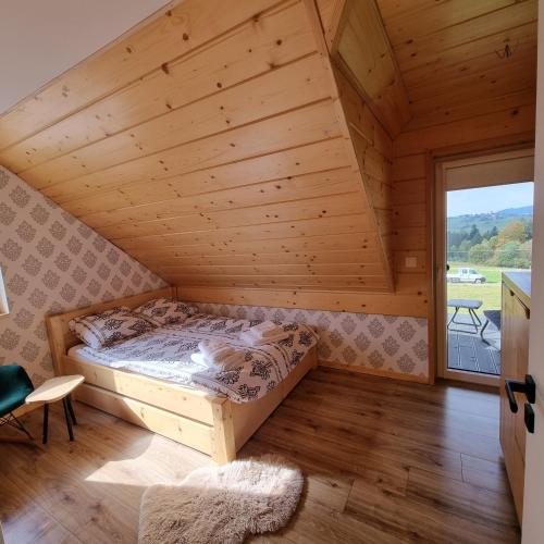 a bed in a room with a wooden ceiling at Sielsko i Diabelsko in Jaworzynka