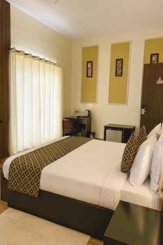 a bedroom with a large bed and a window at Vrindavan Dreams Suits & Luxury Villas in Vrindāvan