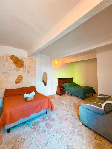 a living room with two beds and a couch at Habitaciones Casa Bule in Oaxaca City