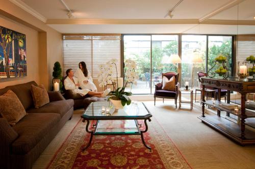 two women sitting in a living room with a couch at Wedgewood Hotel & Spa - Relais & Chateaux in Vancouver