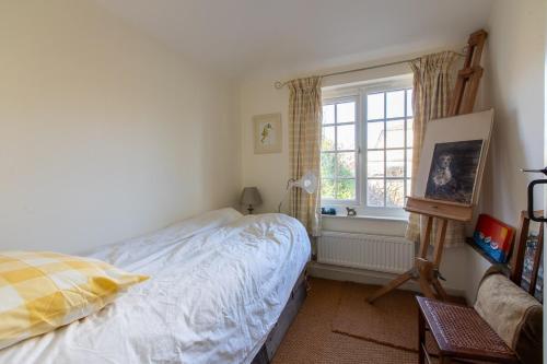 a bedroom with a bed and a window at Victorian 3 Bed Cottage in Sought After Pentyrch in Pentyrch