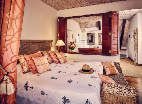 a bedroom with a large bed and a mirror at Spacieuse villa avec piscine privée à Saint-Gilles les Bains 300 m² in Grand Fond