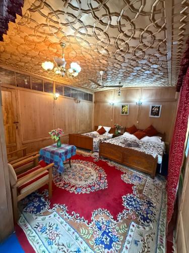 a bedroom with two beds and a red rug at Houseboat Patloo Palace in Srinagar
