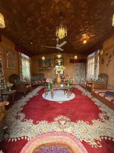a living room with a large red rug at Houseboat Patloo Palace in Srinagar