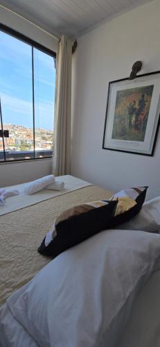 a bedroom with two beds and a large window at Pousada Mar Dos Anjos in Arraial do Cabo