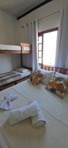 a bedroom with two bunk beds with towels on them at Pousada Mar Dos Anjos in Arraial do Cabo