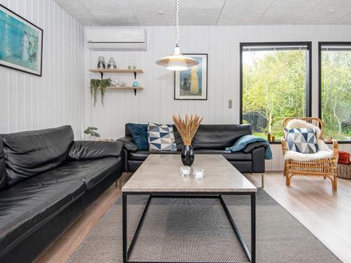 a living room with a black couch and a table at 6 person holiday home in Tarm-By Traum in Tarm