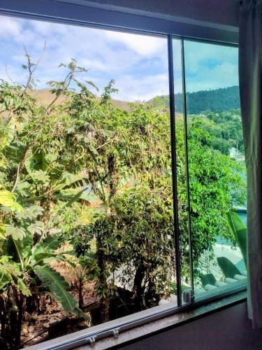 a window with a view of a tree at Pousada Onda de Mar in Angra dos Reis