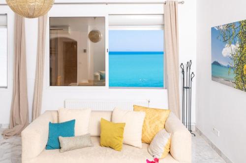 a living room with a white couch with colorful pillows at L'Horizon in Gammarth