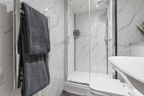 a bathroom with a shower and a sink at Cosy Mezzanine Apartment Leeds City Centre in Leeds