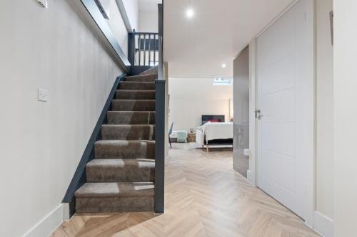 a staircase in a home with white walls and wood floors at Cosy Mezzanine Apartment Leeds City Centre in Leeds