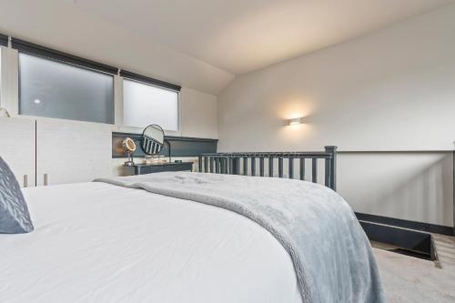 a bedroom with a white bed and a window at Cosy Mezzanine Apartment Leeds City Centre in Leeds