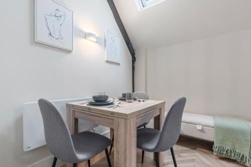 a dining room with a wooden table and chairs at Cosy Mezzanine Apartment Leeds City Centre in Leeds