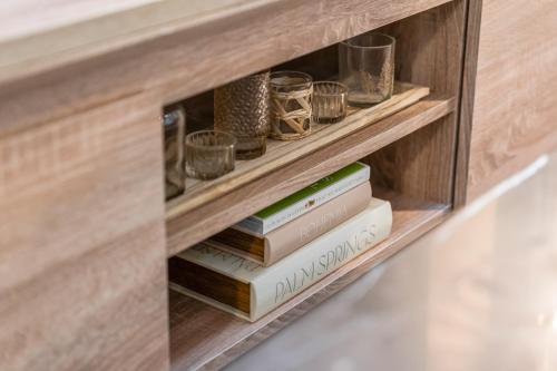 a book shelf with books and glasses on it at Cosy Mezzanine Apartment Leeds City Centre in Leeds