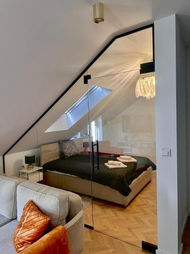 a bedroom with a bed with a glass wall at GOLD PTAK Apartment in Nowy Sącz