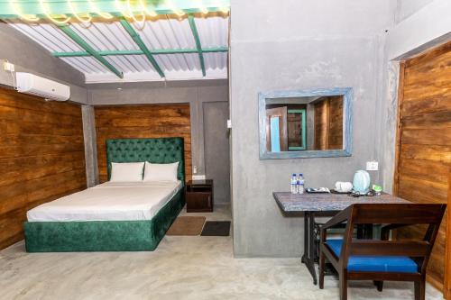 a bedroom with a bed and a table and a mirror at Barramundi in Puttalam