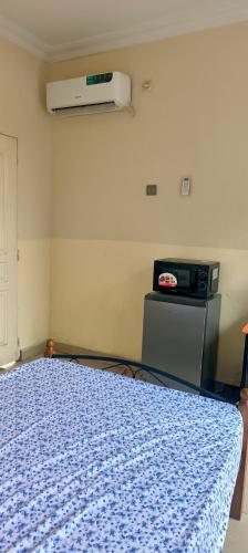 a bedroom with a bed with a blue comforter at Cozy Guest Room in Kinshasa with Balcony and Partial Air-Conditioning in Lemba-Gaba