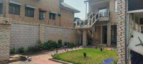 a building with a courtyard with plants and a balcony at Cozy Guest Room in Kinshasa with Balcony and Partial Air-Conditioning in Lemba-Gaba