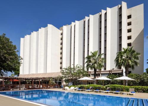 a large white building with a swimming pool at Novotel Dakar in Dakar
