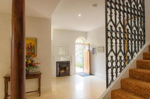 a hallway with a staircase and a fireplace in a house at Broken Hill Outback Church Stay in Broken Hill