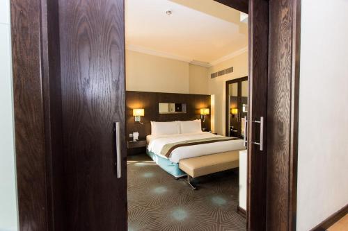 a hotel room with a bed and a open door at Holiday Inn Abu Dhabi by IHG in Abu Dhabi