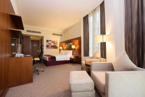 a hotel room with a couch and a bed at Holiday Inn Abu Dhabi by IHG in Abu Dhabi