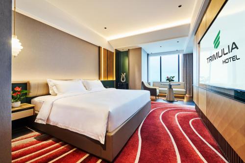 a hotel room with a bed and a flat screen tv at TRIMULIA Hotel in Sihanoukville