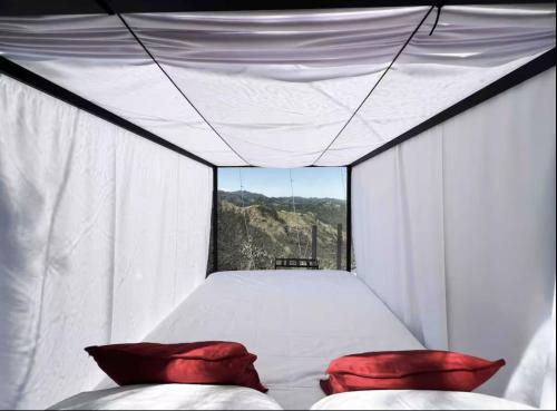 a bedroom with a bed and two pillows in it at Serene Sunsets Bubbletents and Jacuzzi in Orocovis
