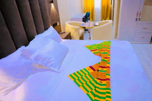a bed with a colorful neck tie on it at Texas Royal Lodge Hotel in Janman