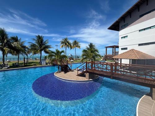 una gran piscina junto a un edificio con palmeras en Paraíso em Tamandaré - Maui Beach, en Tamandaré