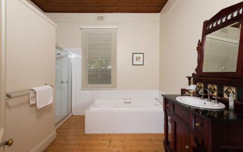 Abaleen House في كوينزكليف: حمام أبيض مع حوض ومغسلة