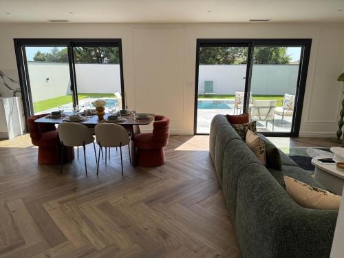 un salon avec un canapé, une table et des chaises dans l'établissement Villa Shaina with pool for 6 people, à Artigues-près-Bordeaux