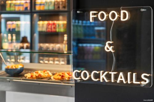 a food and cocktails sign in front of a refrigerator at Aiden by Best Western Odense in Odense