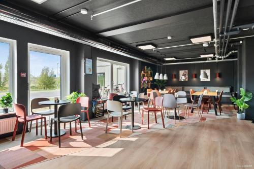 a restaurant with tables and chairs in a room at Aiden by Best Western Odense in Odense