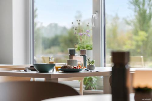 a table with a plate of food on it with a window at Aiden by Best Western Odense in Odense