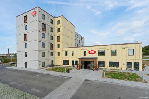 a large yellow and white building with a sign on it at Aiden by Best Western Odense in Odense