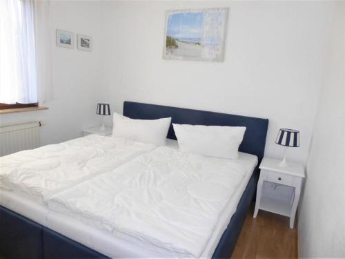 a bed with white sheets and pillows in a bedroom at Baltique Fewo 5 in Glowe