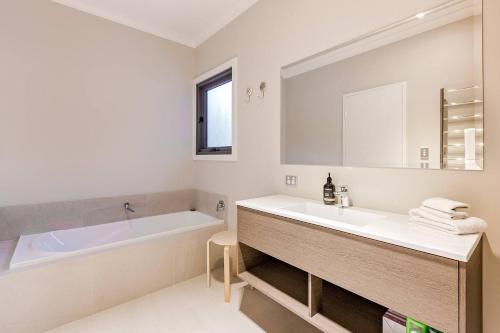 a white bathroom with a tub and a sink at Bonnie and Piper - Lakeside and Wine Country Living in Wilyabrup
