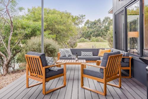 a patio with two chairs and a table on a deck at Bonnie and Piper - Lakeside and Wine Country Living in Wilyabrup
